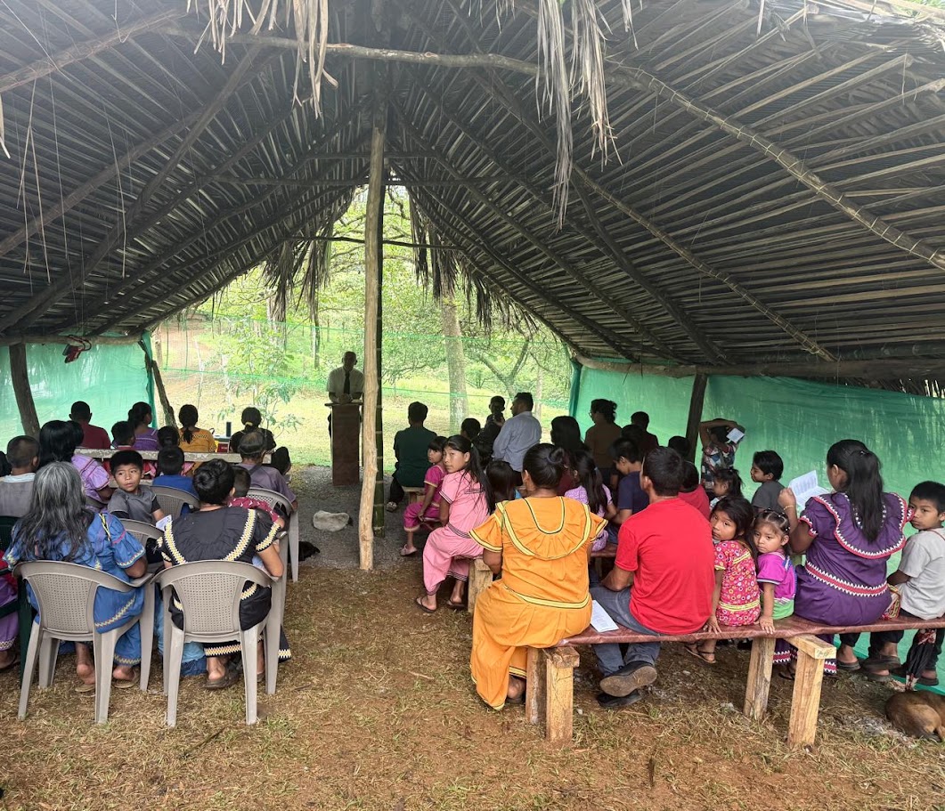 Congregation gathered under a thatched-roof church in rural Panama